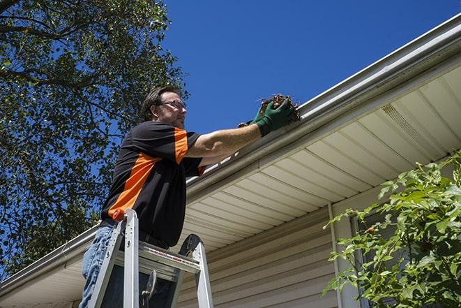 repairman working on a broken rain gutter in Lecompton KS